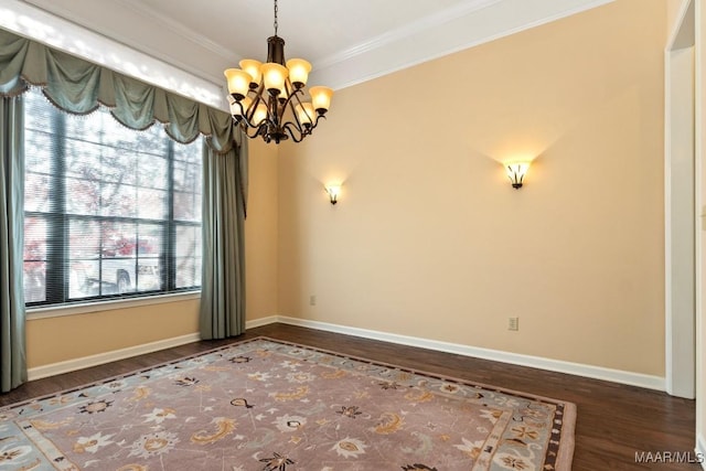 spare room with a notable chandelier, dark hardwood / wood-style floors, and crown molding