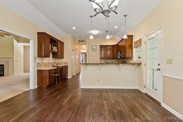 kitchen with pendant lighting, lofted ceiling, a breakfast bar area, and dark wood-type flooring