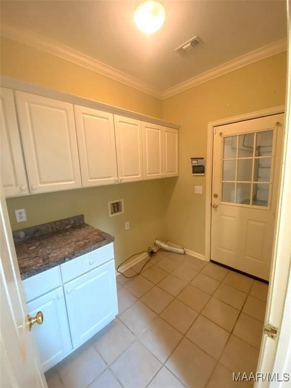 clothes washing area with cabinets, hookup for a washing machine, crown molding, and light tile patterned flooring