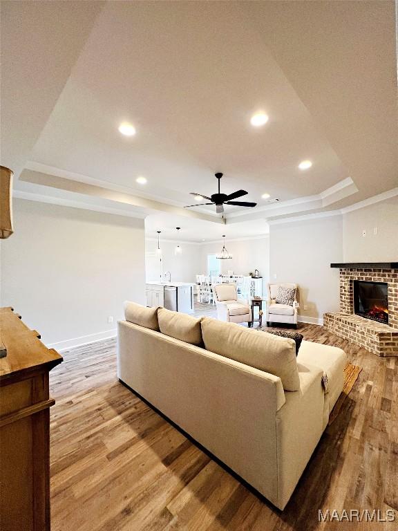 6 Village Knl, Wetumpka, AL 36093 - living area featuring a raised ceiling, wood finished floors, a ceiling fan, and ornamental molding