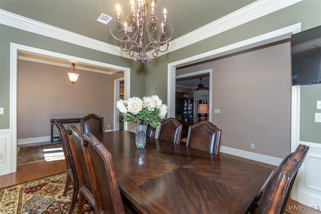 dining area with hardwood / wood-style floors, ceiling fan with notable chandelier, and crown molding