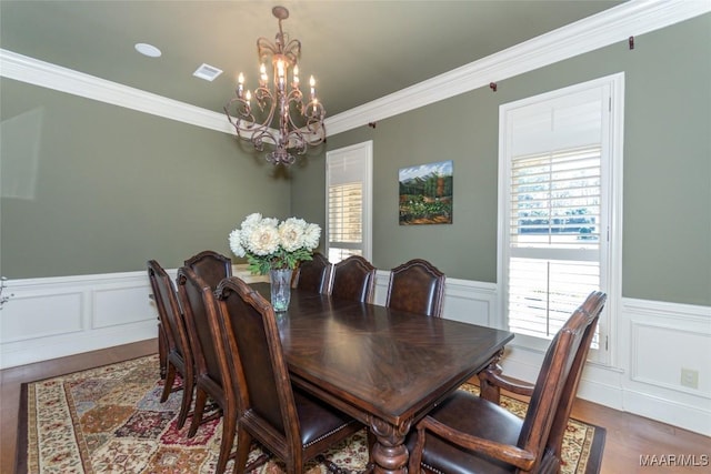 dining room with crown molding, dark hardwood / wood-style flooring, and a chandelier