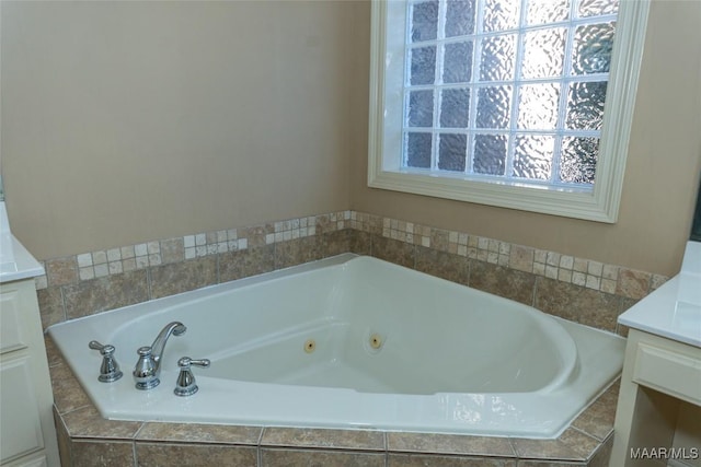 bathroom with vanity and tiled bath