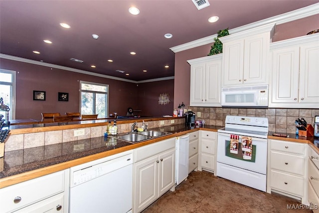 kitchen with a wealth of natural light, sink, white cabinets, and white appliances