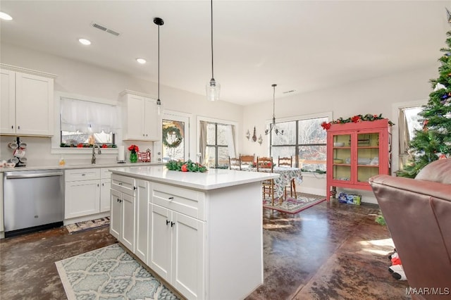 kitchen featuring sink, dishwasher, a kitchen island, pendant lighting, and white cabinets