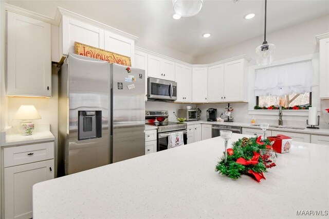 kitchen with pendant lighting, stainless steel appliances, and white cabinetry