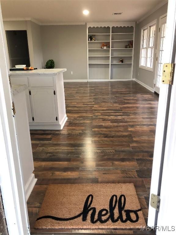 interior space with dark hardwood / wood-style floors, built in features, and crown molding