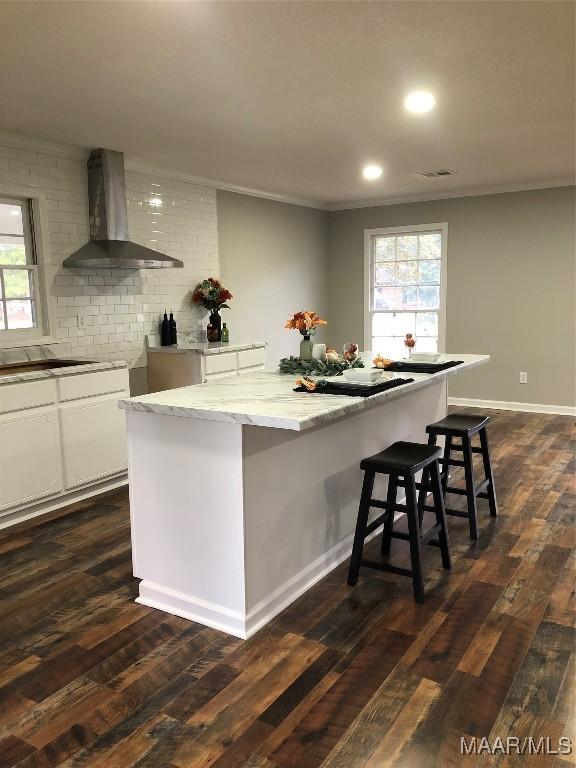 kitchen featuring white cabinets, wall chimney exhaust hood, and dark hardwood / wood-style floors