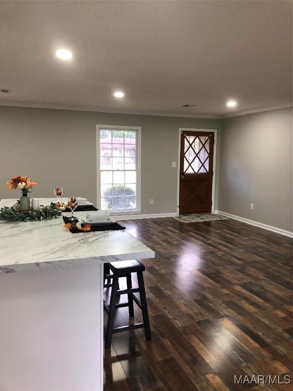 interior space with dark hardwood / wood-style flooring and ornamental molding