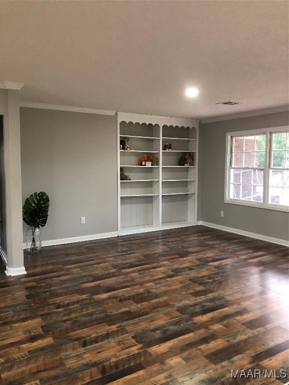 unfurnished living room featuring ornamental molding and dark wood-type flooring