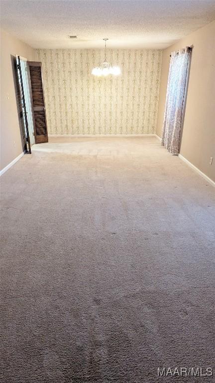 carpeted spare room featuring a textured ceiling