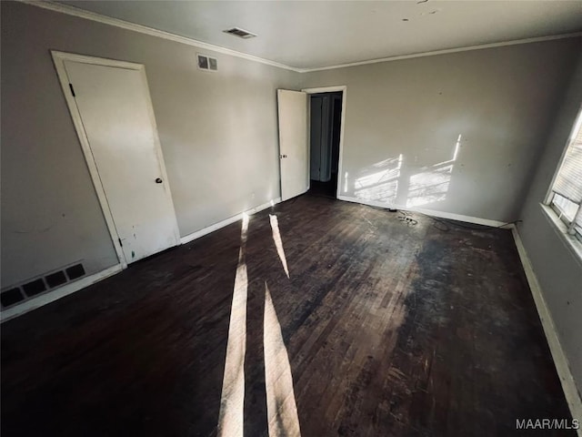 empty room featuring crown molding and dark wood-type flooring