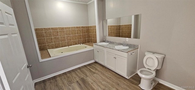 bathroom with vanity, a bath, hardwood / wood-style flooring, toilet, and ornamental molding