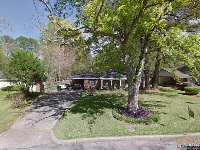 view of front of property featuring a front yard and a carport