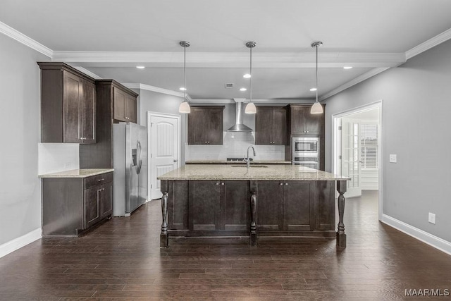 kitchen featuring light stone countertops, stainless steel appliances, wall chimney range hood, pendant lighting, and ornamental molding