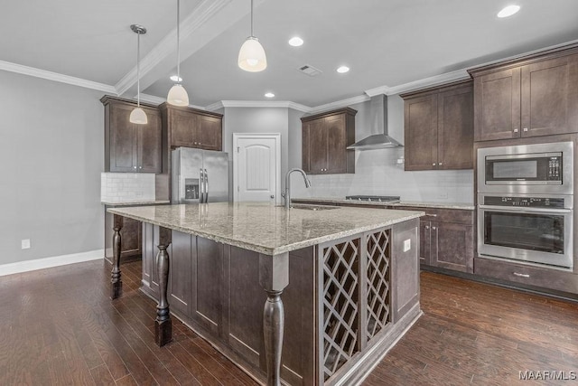 kitchen featuring dark brown cabinetry, sink, wall chimney exhaust hood, hanging light fixtures, and stainless steel appliances