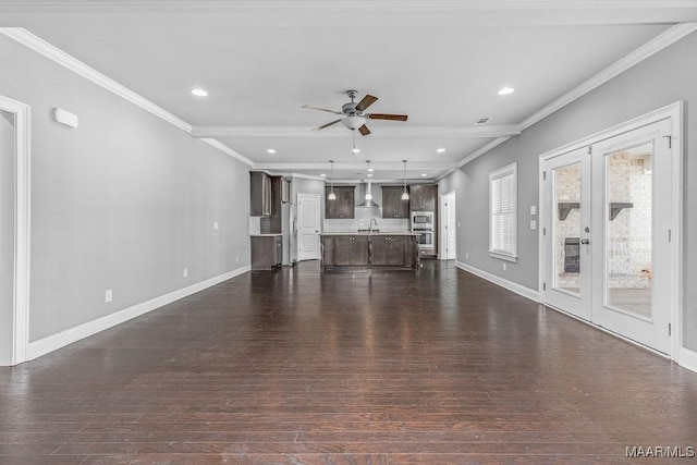 unfurnished living room featuring french doors, dark hardwood / wood-style flooring, crown molding, and sink