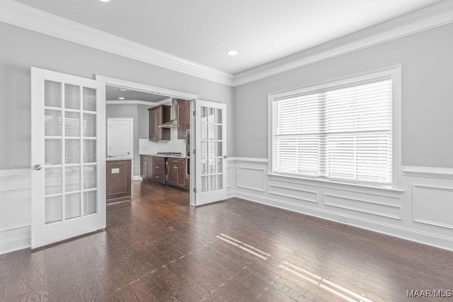 empty room featuring dark hardwood / wood-style flooring, crown molding, and french doors