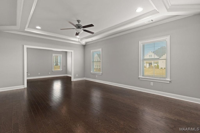 spare room featuring dark wood-type flooring, a raised ceiling, ceiling fan, and ornamental molding