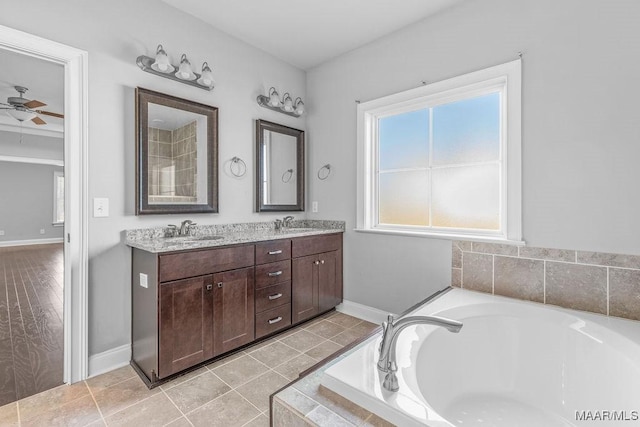 bathroom featuring tile patterned flooring, ceiling fan, vanity, and tiled bath