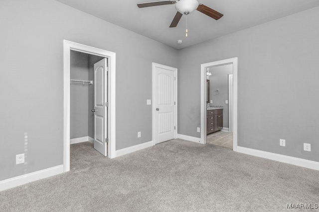 unfurnished bedroom featuring ceiling fan, light carpet, and connected bathroom