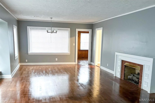 unfurnished living room with a notable chandelier, dark hardwood / wood-style flooring, ornamental molding, and a textured ceiling