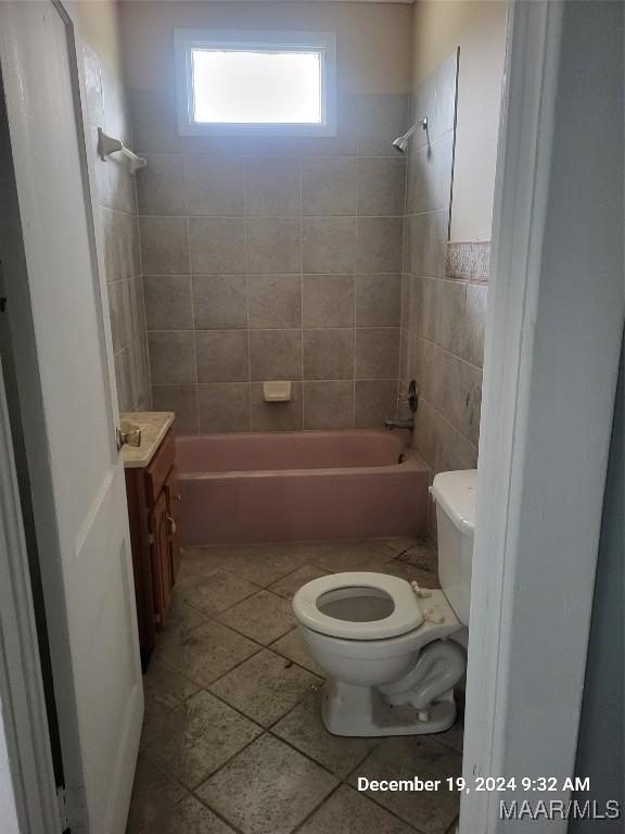 bathroom featuring toilet, tile patterned floors, shower / tub combination, and vanity