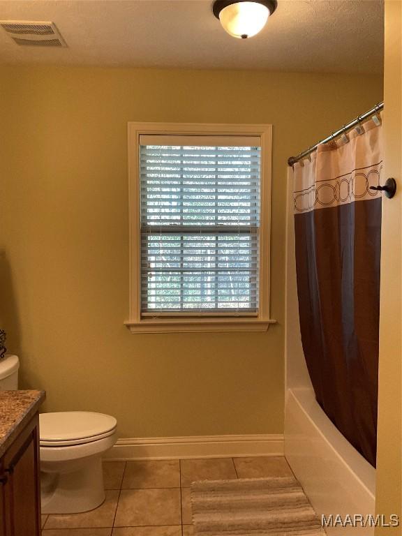 full bathroom with tile patterned floors, vanity, toilet, and shower / tub combo