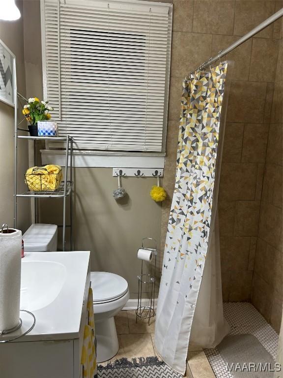 bathroom featuring toilet, tile patterned flooring, vanity, and a shower with shower curtain