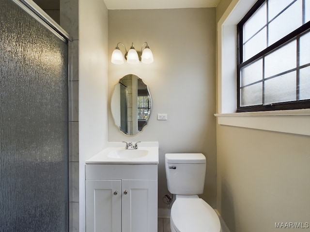 bathroom with walk in shower, vanity, and toilet