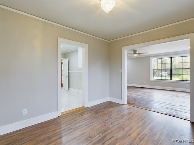 empty room featuring crown molding, ceiling fan, and wood-type flooring