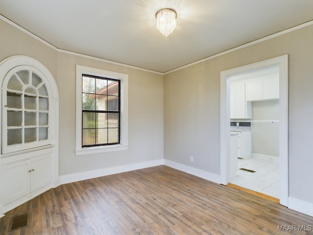 unfurnished room featuring ornamental molding and light hardwood / wood-style flooring