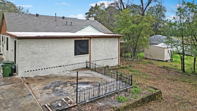 view of side of home with a storage unit and a patio