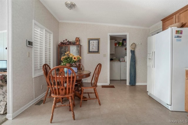 dining space with ornamental molding and washing machine and clothes dryer