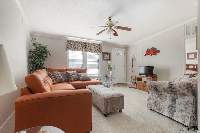 living room featuring light carpet, ceiling fan, a textured ceiling, and ornamental molding