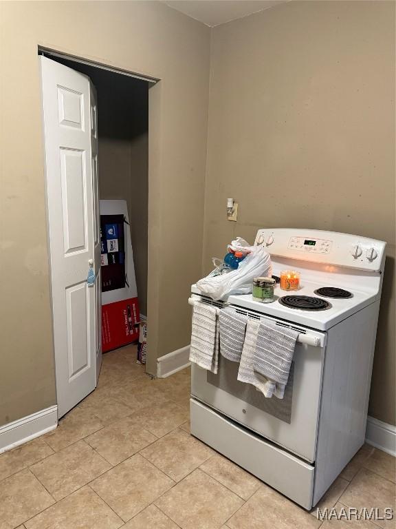 kitchen with light tile patterned floors and white electric range oven