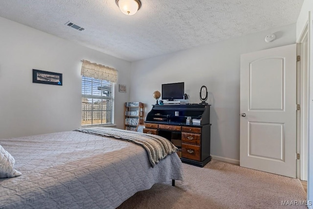 bedroom featuring light carpet and a textured ceiling