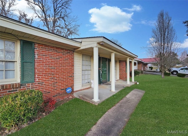 view of side of home with covered porch and a yard