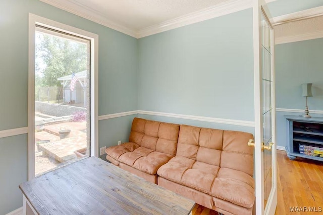 living room with hardwood / wood-style flooring and crown molding