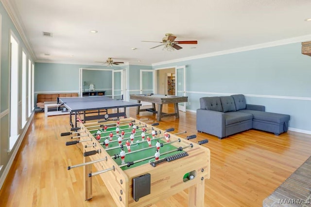 recreation room featuring ceiling fan, wood-type flooring, and ornamental molding