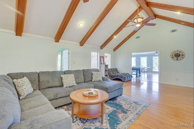 living room with beamed ceiling, ceiling fan, light hardwood / wood-style floors, and high vaulted ceiling