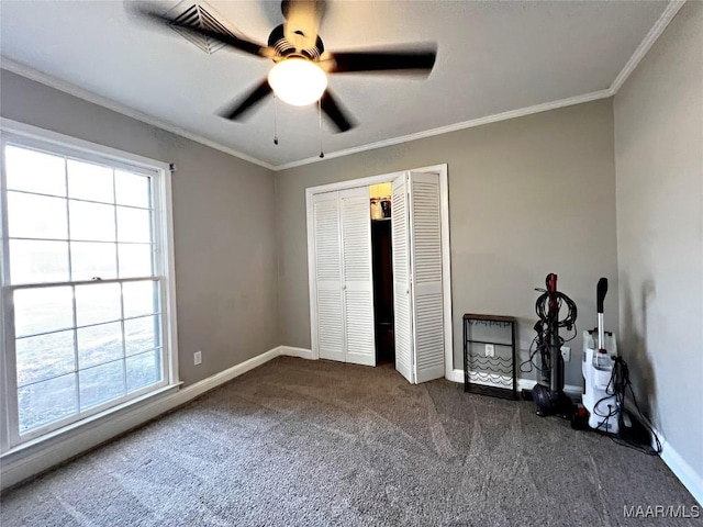 unfurnished bedroom with multiple windows, ceiling fan, ornamental molding, and dark colored carpet