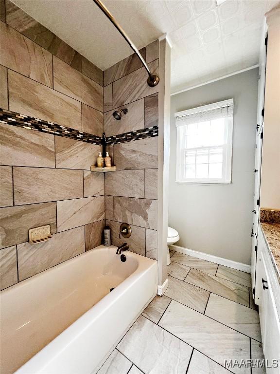 full bathroom with toilet, vanity, and tiled shower / bath combo