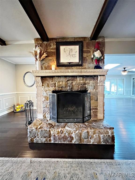 interior details featuring a fireplace, ceiling fan, crown molding, wood-type flooring, and beamed ceiling