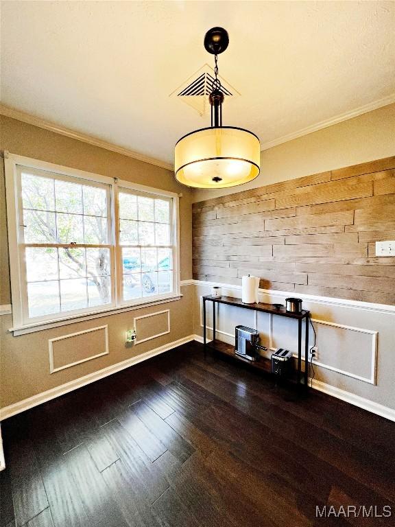 unfurnished dining area with crown molding and dark wood-type flooring