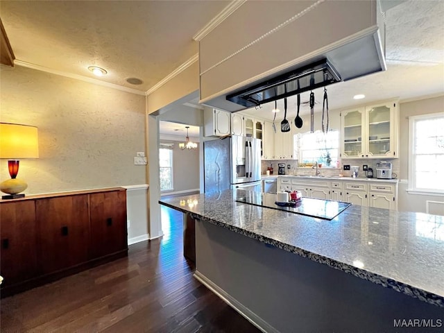 kitchen featuring white cabinetry, hanging light fixtures, crown molding, appliances with stainless steel finishes, and custom exhaust hood