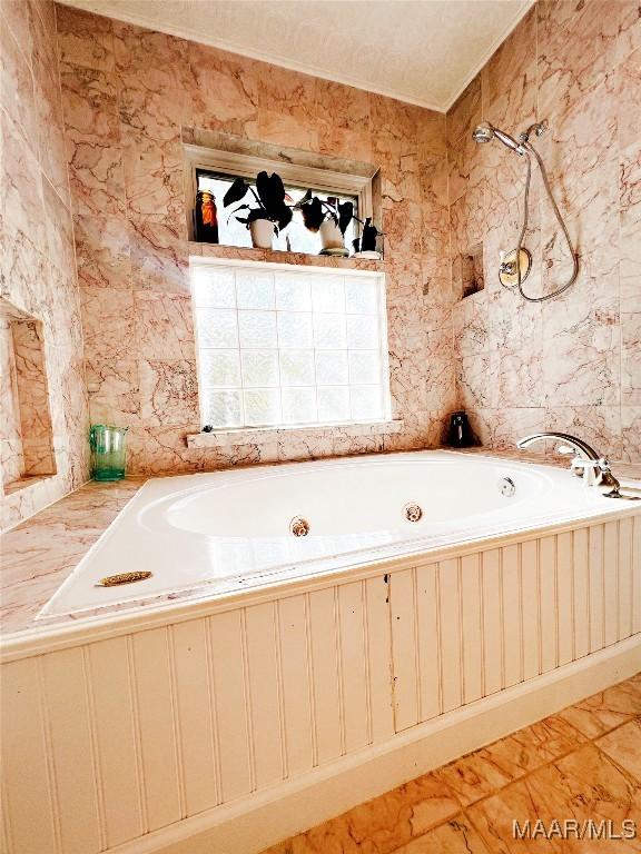 bathroom with a tub to relax in and tile patterned flooring