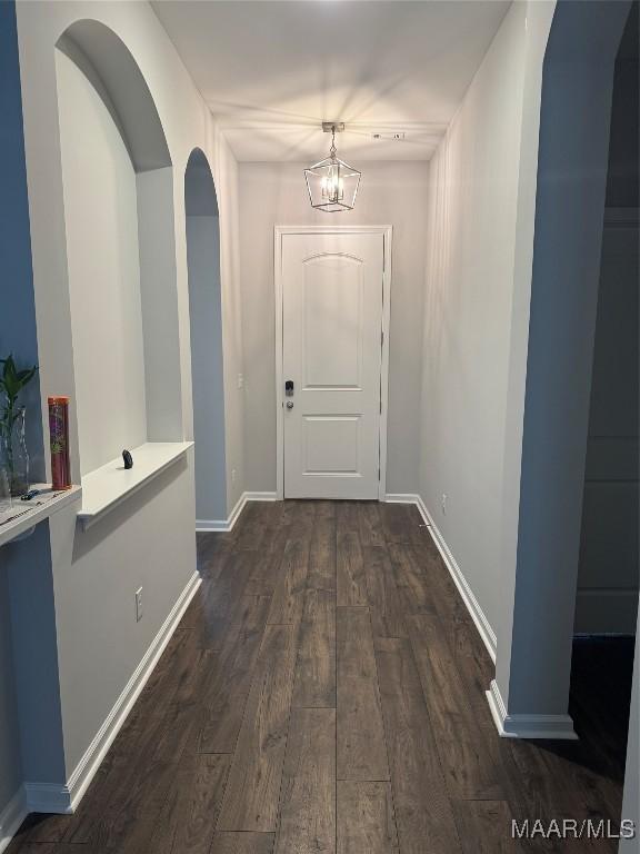 hall featuring dark hardwood / wood-style flooring and a notable chandelier