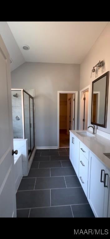 bathroom featuring tile patterned floors, vanity, plus walk in shower, and vaulted ceiling