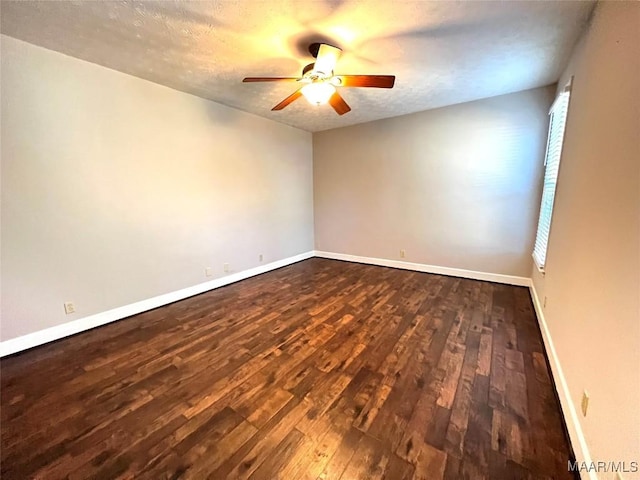 empty room featuring a textured ceiling, dark hardwood / wood-style floors, and ceiling fan